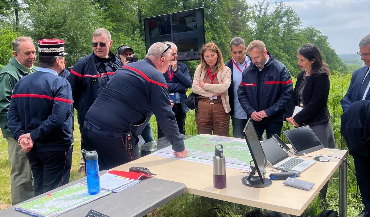 Officiers du SDIS, de l’Office national des forêts et des élus locaux rassemblés autour une carte d'état-major pour écouter les explication du déroulement des opérations