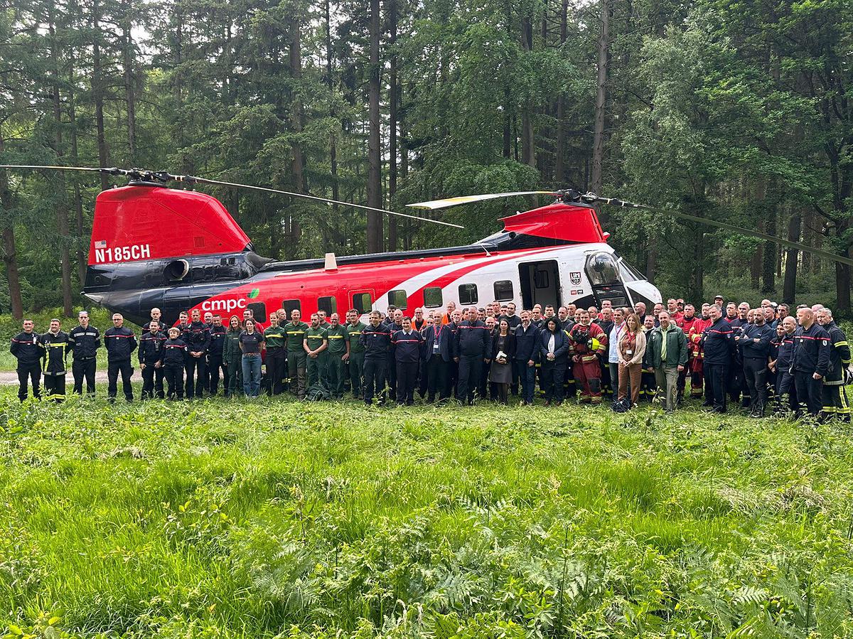Les équipes rassemblées autour de Fanny Anor, préfète de l'Oise, devant l'hélicoptère-bombardier d'eau.